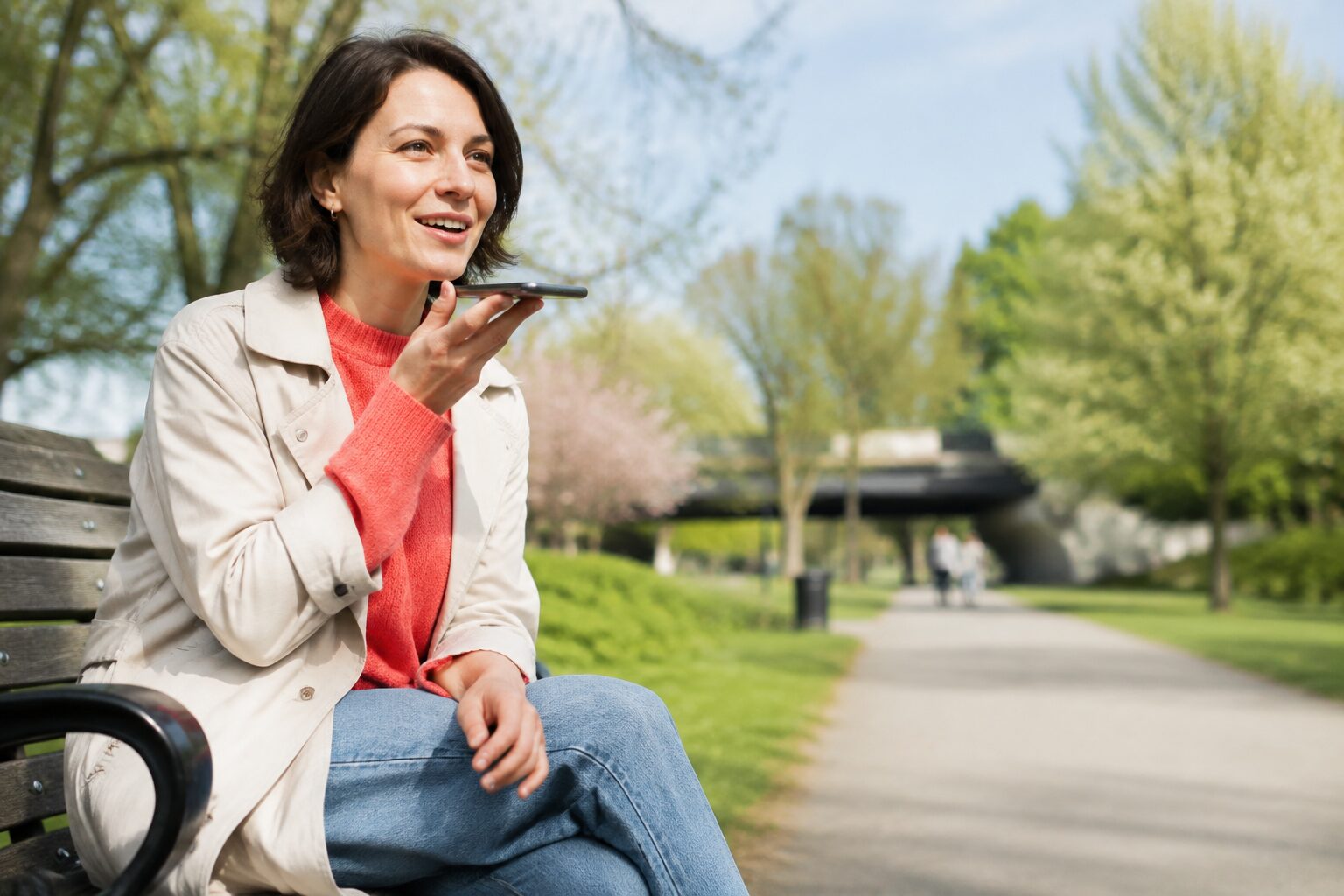 A woman recording a voice message outdoors